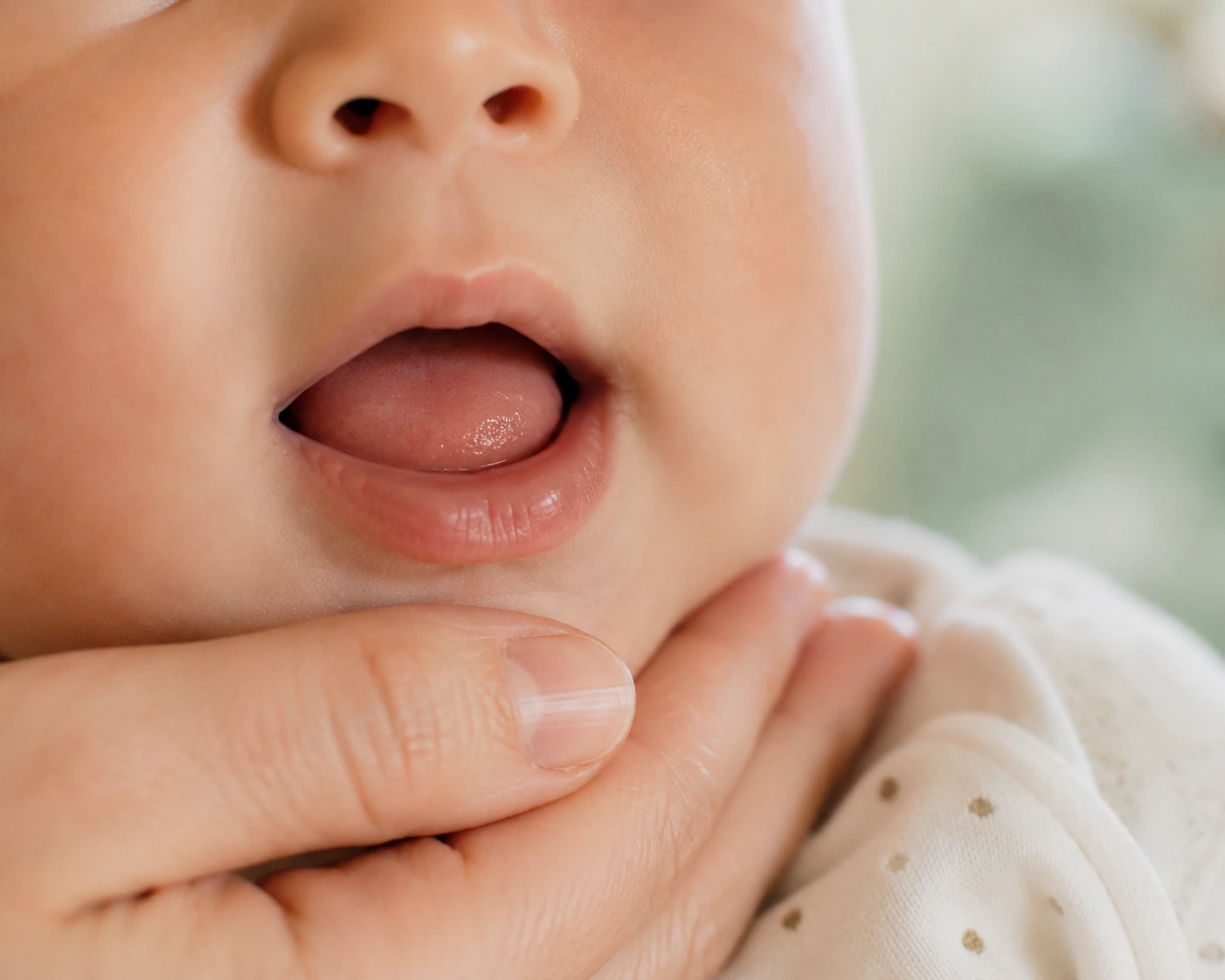 Nahaufnahme vom geöffneten Mund eines Babys nach dem Zungenbändchen durchtrennen mit dem CO₂-Laser